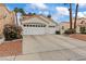 Charming house with a three-car garage, manicured landscaping, and a terra cotta roof at 2024 Spruce Brook Dr, Henderson, NV 89074