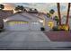 Single Gathering home featuring a well lit front yard, two car garage, and desert landscaping at 2024 Spruce Brook Dr, Henderson, NV 89074