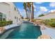 A freeform pool with rock features, palm trees, and manicured landscaping at 2024 Spruce Brook Dr, Henderson, NV 89074
