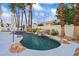 A freeform pool with rock features, palm trees, and manicured landscaping at 2024 Spruce Brook Dr, Henderson, NV 89074
