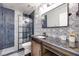 Stylish bathroom features a glass-enclosed shower, patterned wallpaper, and a vanity with a sliding door at 217 Windsong Dr, Henderson, NV 89074