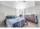 Bright bedroom with a tufted headboard, soft blue bedding, wood floors, and natural light from large windows at 217 Windsong Dr, Henderson, NV 89074