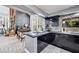Stylish kitchen with dark cabinetry, stone counters, and an adjacent dining area and chalkboard wall at 217 Windsong Dr, Henderson, NV 89074