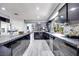 Spacious kitchen with dual islands, dark cabinets, stone counters, and access to the dining and living areas at 217 Windsong Dr, Henderson, NV 89074