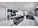Modern kitchen with black cabinets, a center island, stainless steel appliances, and wood-look tile flooring at 217 Windsong Dr, Henderson, NV 89074