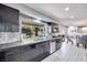 Bright kitchen showcases stone backsplash, garden window, dark cabinets, and open layout to dining area at 217 Windsong Dr, Henderson, NV 89074