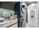 Modern laundry room boasts a sink, stackable washer/dryer, and an entrance to a bathroom at 217 Windsong Dr, Henderson, NV 89074