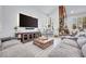 Well-lit living room boasts an oversized sectional couch, a large television and neutral decor at 217 Windsong Dr, Henderson, NV 89074