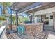 An upscale outdoor kitchen includes a stone bar, grill, and shaded pergola for exquisite outdoor dining at 217 Windsong Dr, Henderson, NV 89074