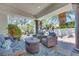 A covered outdoor patio features comfortable seating and a serene view of the tropical pool and waterfall at 217 Windsong Dr, Henderson, NV 89074