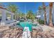 Backyard pool with rock features, diving board and multiple entertainment spaces at 217 Windsong Dr, Henderson, NV 89074
