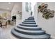 Unique curved staircase featuring carpeted steps, decorative wall art, and access to other rooms at 217 Windsong Dr, Henderson, NV 89074
