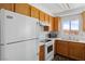 Kitchen with white appliances, wood cabinets, and a sink with view at 2191 Bay Club Dr # 204, Laughlin, NV 89029