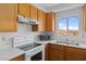 Kitchen with white appliances, wood cabinets, sink with view and microwave at 2191 Bay Club Dr # 204, Laughlin, NV 89029