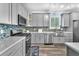 Contemporary kitchen featuring gray cabinets, stainless steel appliances, and stylish blue backsplash at 2268 Alanhurst Dr, Henderson, NV 89052