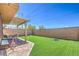 Backyard featuring a covered patio, faux grass, and a seating area, perfect for entertaining at 2293 Sky Island Dr, Henderson, NV 89002