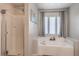 Modern bathroom featuring a separate glass shower, soaking tub, and neutral gray accents and decor at 2293 Sky Island Dr, Henderson, NV 89002