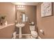 Cozy half bath with pedestal sink, decorative mirror, and warm, neutral color palette at 2293 Sky Island Dr, Henderson, NV 89002