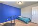 Bedroom with carpet, a twin bed, and a blue accent wall illuminated by a ceiling light at 2293 Sky Island Dr, Henderson, NV 89002