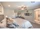 Comfortable primary bedroom with ceiling fan, carpet flooring, and attached workspace with desk and chair at 2293 Sky Island Dr, Henderson, NV 89002