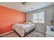 Comfortable bedroom with an orange accent wall, plush carpeting, and a bright window view at 2293 Sky Island Dr, Henderson, NV 89002