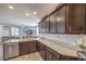 Contemporary kitchen boasting granite countertops, dark cabinets, stainless steel appliances, and open layout to living area at 2293 Sky Island Dr, Henderson, NV 89002