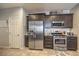 Modern kitchen featuring stainless steel refrigerator, oven, microwave, dark wood cabinetry, and tile flooring at 2293 Sky Island Dr, Henderson, NV 89002