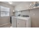 Well-lit laundry room with modern washer and dryer, practical shelving and window at 2293 Sky Island Dr, Henderson, NV 89002