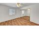 Bedroom with wood-look floors, window, ceiling fan, and mirrored closet doors at 2398 S Lamont St, Las Vegas, NV 89104