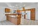 Well-lit kitchen boasts granite countertops, tile floors, wooden cabinetry, and modern white appliances at 2398 S Lamont St, Las Vegas, NV 89104