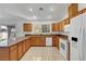 Functional kitchen featuring tiled floors, granite countertops, wood cabinets, and updated appliances at 2398 S Lamont St, Las Vegas, NV 89104