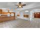 Spacious living room with tile flooring, ceiling fan, and built-in shelving near the kitchen and front entry at 2398 S Lamont St, Las Vegas, NV 89104
