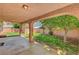 A covered patio area that provides shade, overlooking the greenery of the backyard at 2398 S Lamont St, Las Vegas, NV 89104