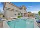 Lush backyard featuring a sparkling pool, spa, and comfortable lounge area perfect for enjoying the outdoors at 2486 Dragon Fire Ln, Henderson, NV 89052