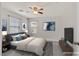 This staged bedroom has a bed, side tables, television, ceiling fan and two windows at 2486 Dragon Fire Ln, Henderson, NV 89052