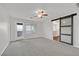 Large bedroom with natural light, balcony access, and a barn door leading to bathroom at 2486 Dragon Fire Ln, Henderson, NV 89052