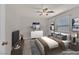 This is a staged bedroom with a ceiling fan, tv and neutral decor at 2486 Dragon Fire Ln, Henderson, NV 89052
