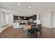 Modern eat-in kitchen with dark cabinets, stainless steel appliances, granite countertops, and island with seating at 2486 Dragon Fire Ln, Henderson, NV 89052