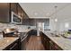 Modern kitchen with granite countertops, stainless steel appliances, and dark wood cabinets at 2486 Dragon Fire Ln, Henderson, NV 89052