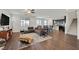 Bright, open-concept living room with hardwood floors, a modern sofa, and seamless flow to the dining area at 2486 Dragon Fire Ln, Henderson, NV 89052