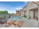Backyard view of a sparkling pool with spa, lounge chairs, and patio seating for outdoor enjoyment at 2486 Dragon Fire Ln, Henderson, NV 89052