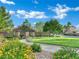 Serene community park featuring lush green grass, colorful flowers, and a paved walkway at 2749 Invermark St, Henderson, NV 89044
