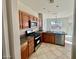 Bright kitchen with wood cabinets, stainless steel appliances, stone counters, and tile floors at 2749 Invermark St, Henderson, NV 89044