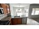 Well-lit kitchen with stainless steel dishwasher, granite countertops and wood cabinets at 2749 Invermark St, Henderson, NV 89044