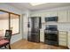 Modern kitchen with stainless steel appliances, ample cabinetry, and an adjacent breakfast nook at 3128 Faiss Dr, Las Vegas, NV 89134