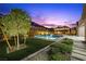 Inviting backyard features a modern pool with water features, lush landscaping, and mountain views at 3131 Reverence Heights Ln, Las Vegas, NV 89138