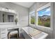 Bright primary bath includes a soaking tub with neighborhood views, dual sinks, and textured accent wall at 3131 Reverence Heights Ln, Las Vegas, NV 89138