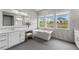 Bright primary bath showcases dual sinks, large soaking tub, and gray tile flooring at 3131 Reverence Heights Ln, Las Vegas, NV 89138