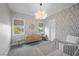 Charming Bedroom featuring wallpaper with leaf design, modern light fixture and neutral furnishings at 3131 Reverence Heights Ln, Las Vegas, NV 89138