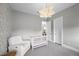Cozy Bedroom featuring stylish lighting, white crib and comfortable seating area at 3131 Reverence Heights Ln, Las Vegas, NV 89138